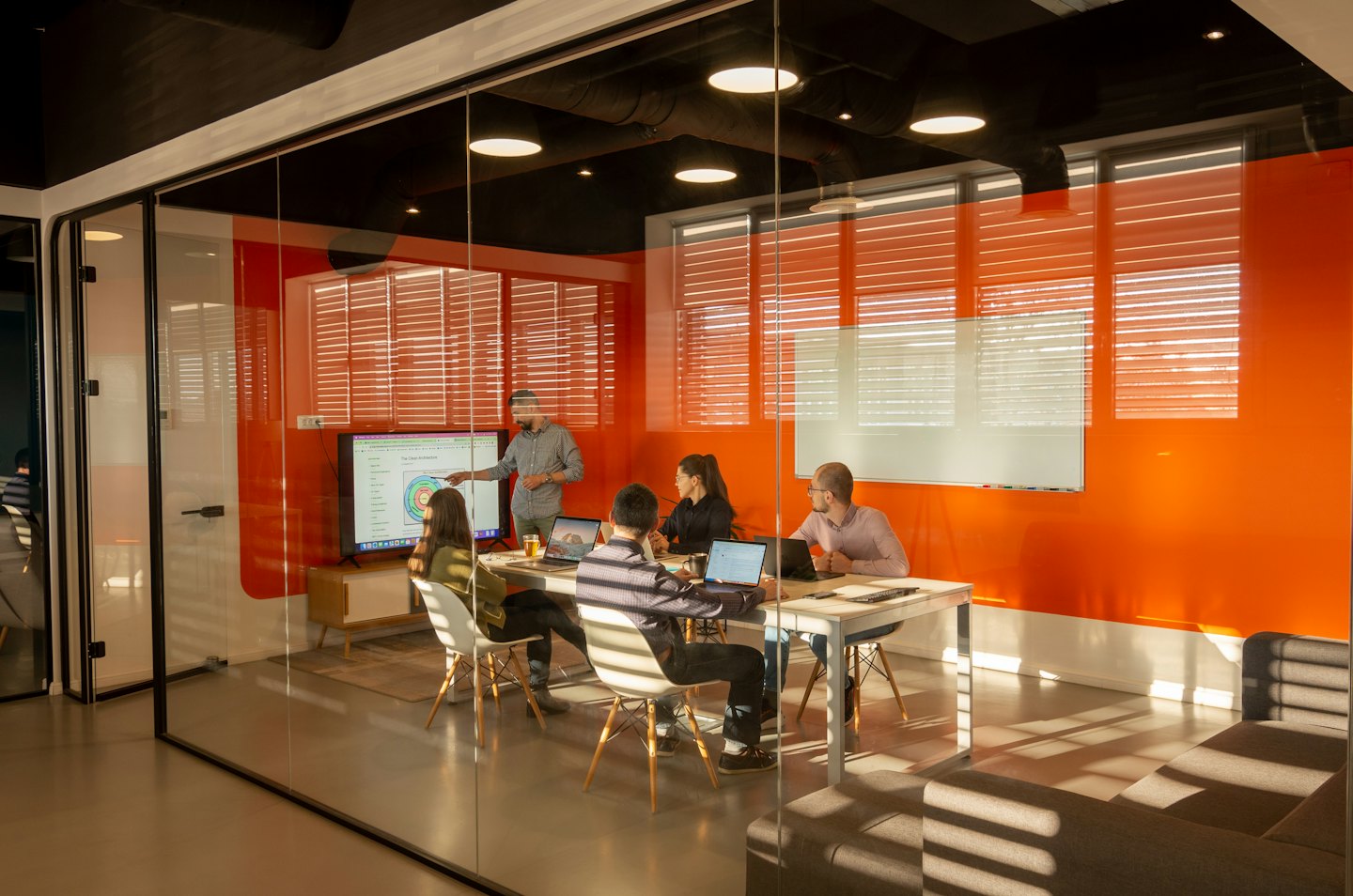 Riunione di un team di lavoro in una moderna sala conferenze con schermo.