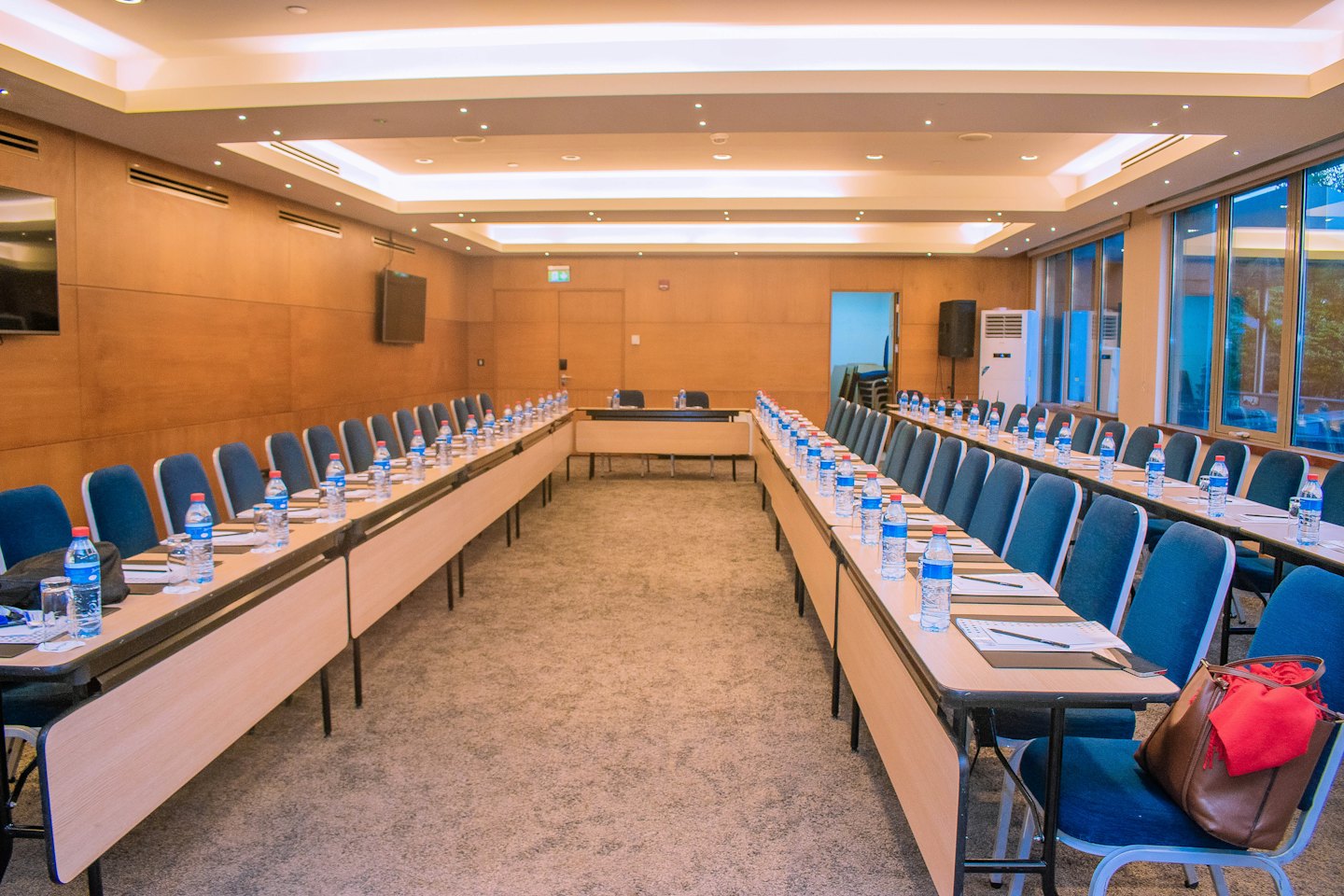 Sala riunioni moderna con tavoli in legno disposti per una riunione.